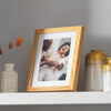 Oak photo frame on shelf with family portrait
